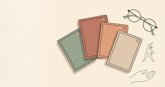 Illustration of four fanned journal covers in different colors with corner accent dots, beside a pair of glasses